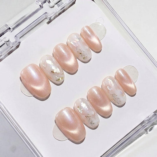 Close-up of Eyecandys Champagne Toast reusable press-on nails showcasing a luminous champagne cat-eye finish, iridescent abalone flakes, and fine silver glitter accents.