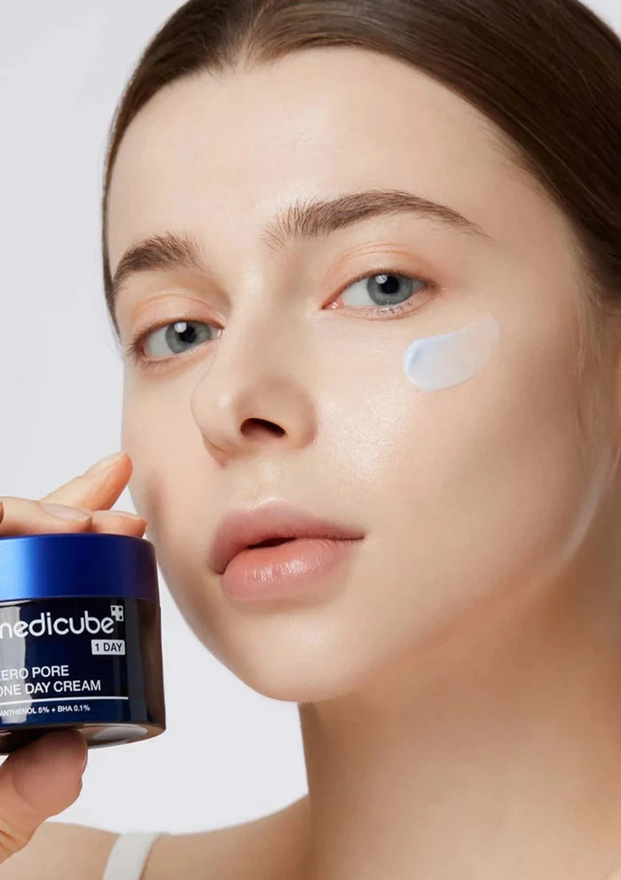 Woman applying Medichube cream to her face with a white background