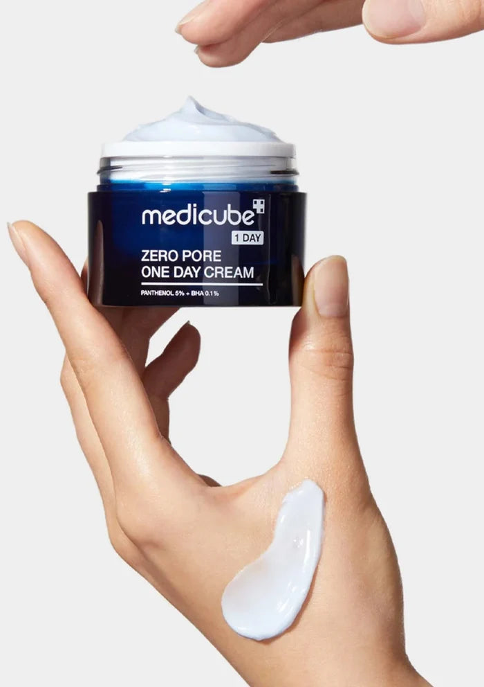 Hand holding a jar of Medicube Zero Pore One Day Cream with a white background