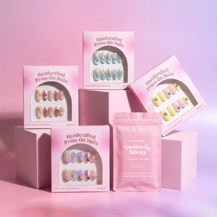 Four boxes of EyeCandys' Neutrals & Basics Press-On Nail Set and a pink packet labeled “Insanely Sticky” are displayed on pale pink geometric blocks with a pink gradient background. Each box features a different Neutrals & Basics design, offering a salon-quality gel manicure look at home.