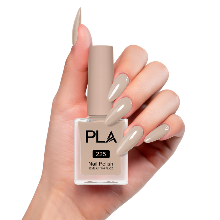 Hand holding a brown nail polish bottle with matching nails on a white background
